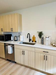 a kitchen with a sink and a microwave at Studio Modern luxe apartment in Vancouver