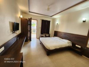 a hotel room with a bed and a television at Rani Palace Hotel And Resort in Kishangarh