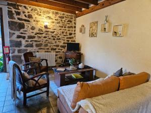 a living room with a couch and a table at Les 3 rossignols in Taden