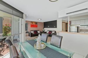 a living room with a glass table and chairs at Yarrawonga Lakeside Apartment 49 in Mulwala
