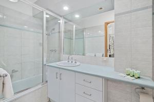 a white bathroom with a sink and a shower at Yarrawonga Lakeside Apartment 49 in Mulwala +7 photos