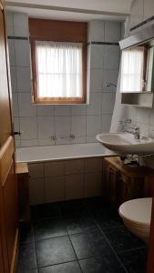 a bathroom with a bath tub and a sink at Vieux Valais EG Ost in Bellwald