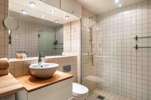 a bathroom with a sink and a shower and a toilet at Stilren leilighet midt i Oslo sentrum in Oslo