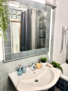 lavabo blanco en el baño con espejo en James Bond Apartment old town en Bratislava