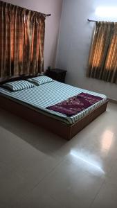 a bed sitting in a room with a window at Happy Beach House in Chennai