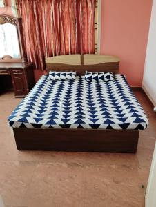 a bed with a blue and white checkered mattress at Happy Beach House in Chennai