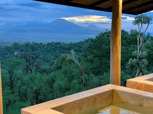 a view of the mountains from a room with a bath tub at Sumberkima Hill Retreat in Pemuteran