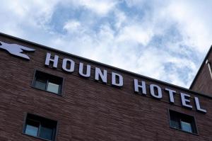 a hotel sign on the side of a brick building at Hound Hotel Jeonju Deokjin in Jeonju