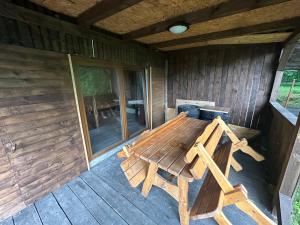 a wooden bench sitting on the back of a cabin at Chata in Nové Město pod Smrkem