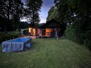 eine kleine Hütte im Gras mit Pool davor in der Unterkunft Chata in Nové Město pod Smrkem