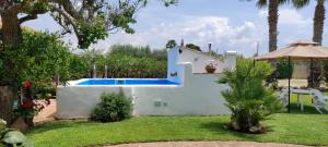 een wit huis met een zwembad in een tuin bij Casa Vacanze ANTICO CASALE in Marsala