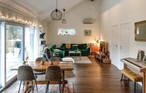 a living room with a green couch and a table at Lovely Home In Blid With Kitchen in Blidö