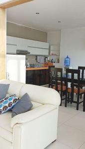 a living room with a white couch and a kitchen at Casa de Playa en Tortugas - Beach House Tortugas in Tortuga