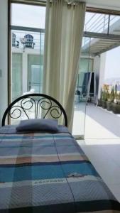 a bedroom with a bed with a blanket and a window at Casa de Playa en Tortugas - Beach House Tortugas in Tortuga