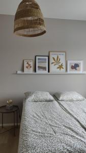 a bedroom with a bed and a shelf with pictures at Green Getaway - near Helsinki Vantaa Airport, top-floor, free parking & wifi in Vantaa