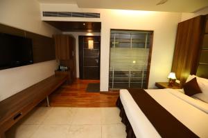 Habitación de hotel con cama y TV en Twin Tree en Nueva Delhi