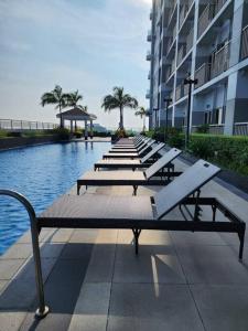 a row of benches sitting next to a pool of water at CitiBay View Staycation in Manila