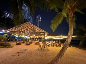 a restaurant on a beach at night with a palm tree at Wind Serenity & FOC Netflix Access Country Garden Danga Bay 3BR # 6-11 pax by Minshuku in Johor Bahru