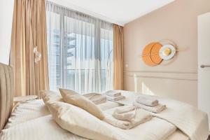 a white bed in a room with a large window at Wave - Aurum II Apartment - Front Sea View in Międzyzdroje