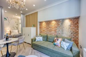 een woonkamer met een bank en een bakstenen muur bij Leone Central Luxury Apartments - Happy Rentals in Zagreb