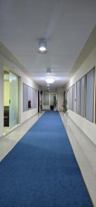 un couloir avec un tapis bleu dans un bâtiment de bureau dans l'établissement معيذر للشقق المفروشه, à Doha