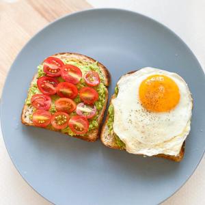古爾岡的住宿－Staykr Rooms & BnB，蓝盘烤面包上的鸡蛋和西红柿