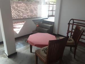 a room with a table and two chairs and a window at Pahalage Guesthouse in Beruwala
