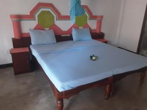 a bedroom with a bed with a large headboard at Pahalage Guesthouse in Beruwala