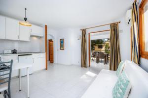 a kitchen and living room with a couch and a table at Apartamento mhm 5 in Cala Ratjada