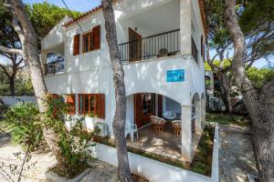 a white house with trees in front of it at Apartamento mhm 5 in Cala Ratjada