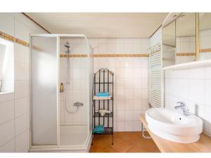 a white bathroom with a shower and a sink at Hirschen Apartments in Oberreute