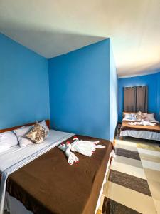 a blue room with two beds with stuffed animals on it at Juanito's Resort in Tangalan