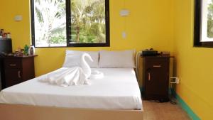uma cama com uma escultura de cisne branco em L&L Beach Resort em Pandan