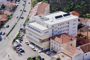 an overhead view of a large white building on a city street at Hotel Dompes in Mostar