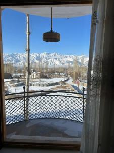 una ventana con vistas a una montaña nevada en The Morning Sky hotel, en Leh