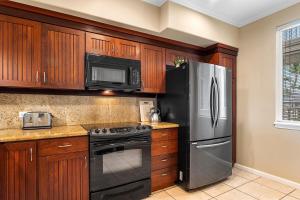 a kitchen with a stainless steel refrigerator and microwave at Waikoloa Beach Villas F22 condo in Waikoloa +32 photos