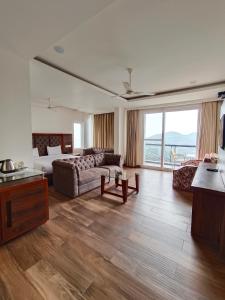 a large living room with a couch and a table at Hotel Chail Residency in Chail