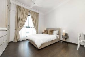 um quarto branco com uma cama e uma janela em VSummer CozyHaven 4br nr CIQ R&F by Our Stay em Johor Bahru