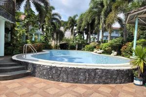 a swimming pool with a stone wall around it at Villa Celine Laguna in Masaya +20 photos