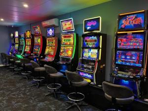 a row of slot machines in a room with chairs at The Anglers Inn in Wallaroo
