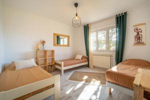 een slaapkamer met 2 bedden en een raam bij Oco Surf Camp - matériel de surf, accès studio de yoga et cuisine commune inclus in Lit-et-Mixe