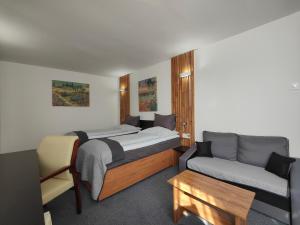 1 dormitorio con 1 cama y 1 sofá en Hotel P7 en Lučenec
