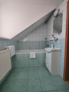 a bathroom with a bath tub and a sink at Hotel P7 in Lučenec