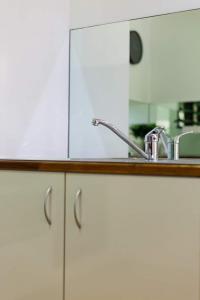 a kitchen counter with a sink and a mirror at Great Northern Beach House in Yorkeys Knob
