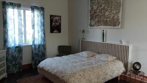 um quarto com uma cama e uma janela em Maison de campagne em Puycornet