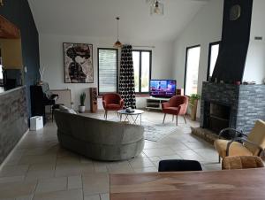 uma sala de estar com um sofá e uma lareira em Maison de campagne em Puycornet