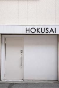 a white building with a hoxka sign on it at Hokusai Stay in Osaka