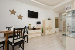 a dining room with a table and chairs and a television at Stars Apartment Andersa by Renters in Warsaw