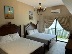 a bedroom with two beds and a balcony at The Farmhouse in Ipoh