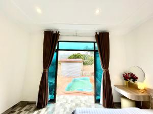 una camera da letto con vista sull'acqua attraverso la finestra di Milky Villa Moc Chau a Mộc Châu